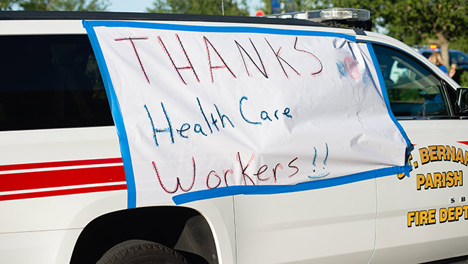 St. Bernard Parish Fire Department truck with a handwritten sign taped to window that reads Thanks Health Care Workers
